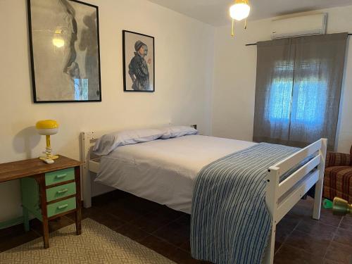 a bedroom with a bed and a table and a window at LA GORDA in Castilblanco de los Arroyos