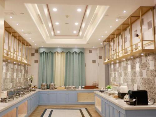salon fryzjerski z niebieskimi szafkami i zielonymi zasłonami w obiekcie Magnotel Hotel Qionghai Wanquanhe Aihua Road w mieście Qionghai