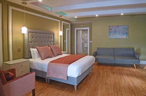 Moy Hotel في مايو: غرفة نوم بسرير كبير وأريكة