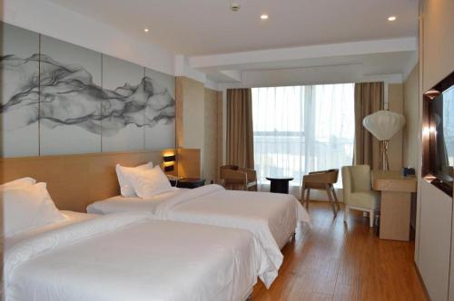a hotel room with two beds and a desk at Metropolo Hotel Kunshan Jinying International Kun Opera Theater in Kunshan
