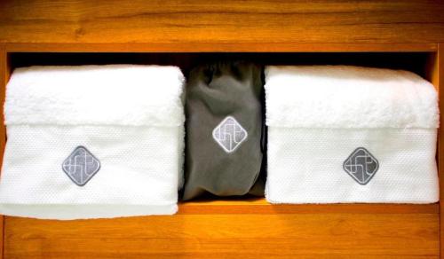 duas toalhas em cima de uma prateleira de madeira em Chonpines Hotels·XiNing Qingzang Building em Xining