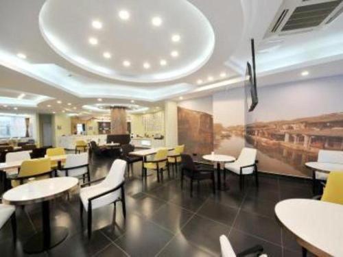 un restaurante con mesas y sillas en una habitación en Metropolo Hotel Kunshan Jinying International Kun Opera Theater en Kunshan