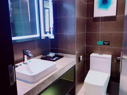 a bathroom with a white sink and a toilet at Xana Lite Beijing Huangcun West Street Metro Station in Daxing