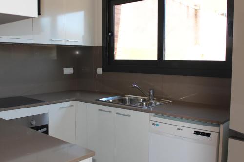 cocina con fregadero y ventana en Residencial Super Stop Cases Torre Valentina, en Sant Antoni de Calonge