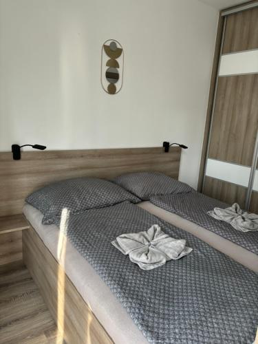 ハイドゥソボスローにあるOasis Apartmanのベッドとタオル2枚のある寝室