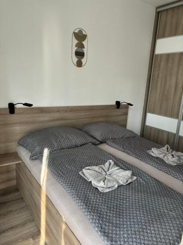 a bedroom with a bed with two towels on it at Oasis Apartman in Hajdúszoboszló