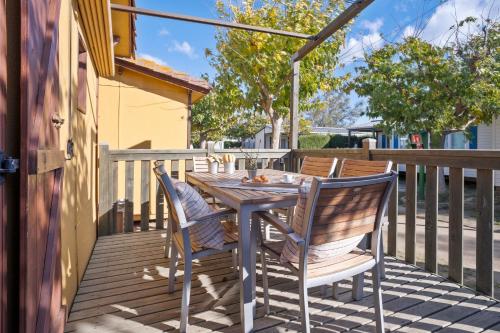 a wooden table and chairs on a deck at Camping Castell Mar in Empuriabrava