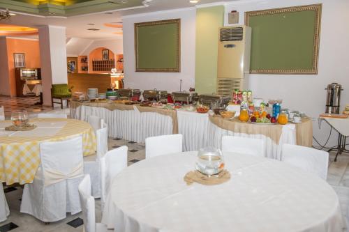 a banquet hall with white tables and white chairs at Verdelis Inn in Ancient Epidavros