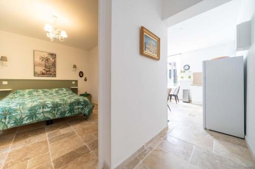 a bedroom with a bed with a green bedspread at La maison de Lili aux portes du Luberon in Cavaillon