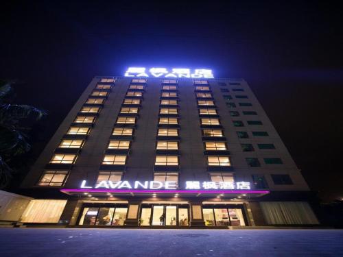 budynek z oświetlonym znakiem na górze w obiekcie Lavande Hotels·Qionghai Boao w mieście Xinshi