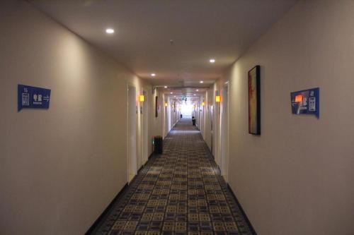 a hallway with a long hallway with a tile floor at PAI Hotel Hami Baoda Logistics Park Test Station in Qumul