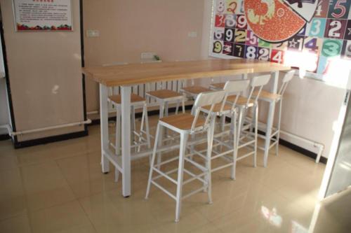 a table and some stools in a room at PAI Hotel Hami Baoda Logistics Park Test Station in Qumul