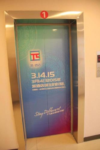 un ascensor en un edificio con un cartel en PAI Hotel Hami Baoda Logistics Park Test Station en Hami