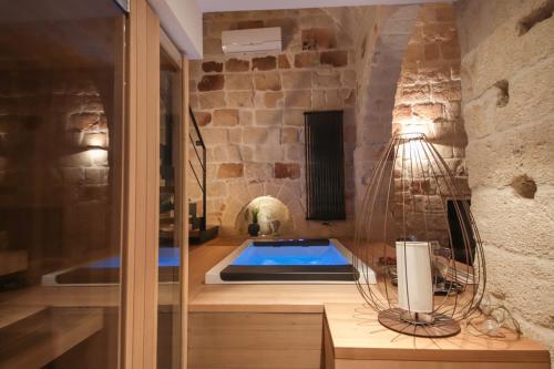 een badkamer met een hot tub in een stenen muur bij SUITE & SPA VIA VENETO in Monopoli