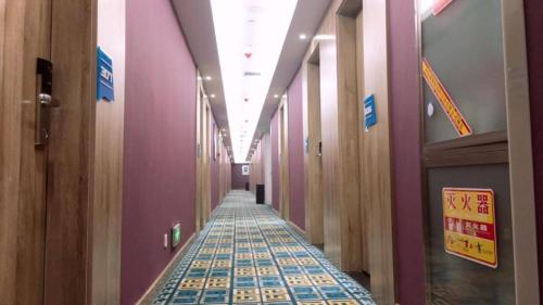 een hal met paarse muren en een tegelvloer bij PAI Hotels·Hanzhong Middle XinHang Road Chengdong Bus Terminal in Hanzhong