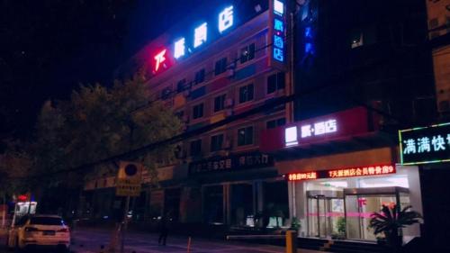 een gebouw met neonborden aan de zijkant bij PAI Hotels·Hanzhong Middle XinHang Road Chengdong Bus Terminal in Hanzhong