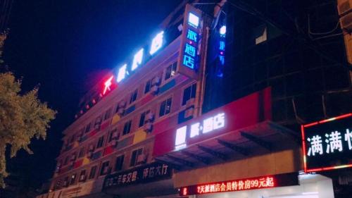 een gebouw met neonborden aan de zijkant bij PAI Hotels·Hanzhong Middle XinHang Road Chengdong Bus Terminal in Hanzhong