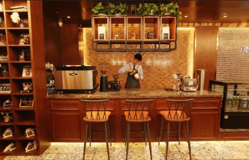 a woman standing behind a counter in a kitchen at James Joyce Coffetel Linfen Xiangyang West Road in Linfen