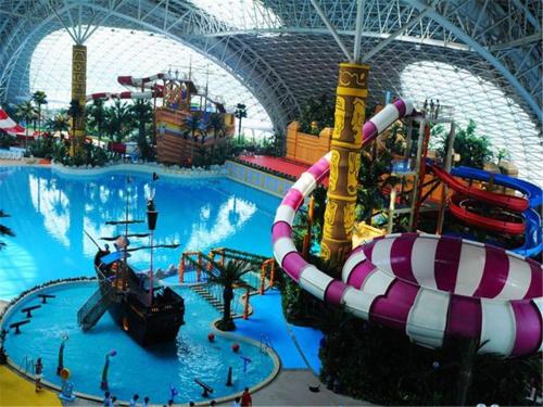 a large indoor water park with a water slide at Xana Lite Tianjin Beizhakou Town in Jinnanqu