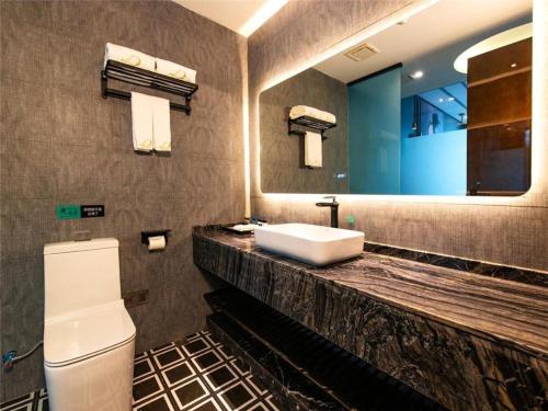 瀘州市にあるXana Hotelle·Hotel Luzhou Baizitu Squareのバスルーム(洗面台、トイレ、鏡付)