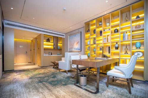 HutouにあるLakehome Hotel Konggangの黄色の壁の客室で、テーブルと椅子が備わります。