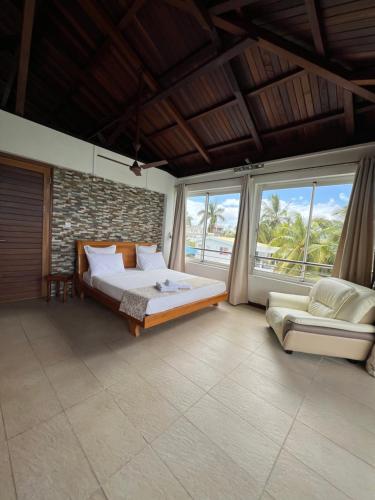a bedroom with a bed and a couch and windows at Blue Bay Beachfront 3 bedrooms Penthouse in Blue Bay