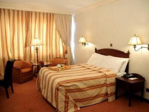 哈科特港的住宿－Rachael Hotel，酒店客房带一张大床和一把椅子