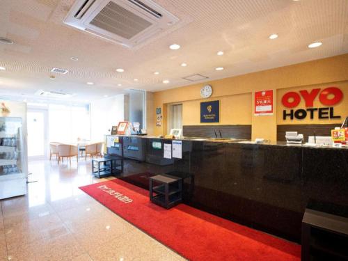 a lobby of a hotel with a counter and a red rug at OYO Sun Hotel Kokubu Kagoshima in Kirishima