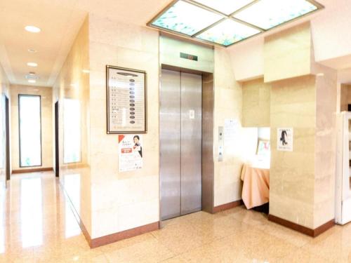 a hospital hallway with a elevator and a bed at OYO Sun Hotel Kokubu Kagoshima in Kirishima