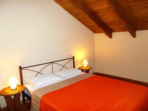 a bedroom with a red bed with two lamps at Porto Katsiki Blu in Athani