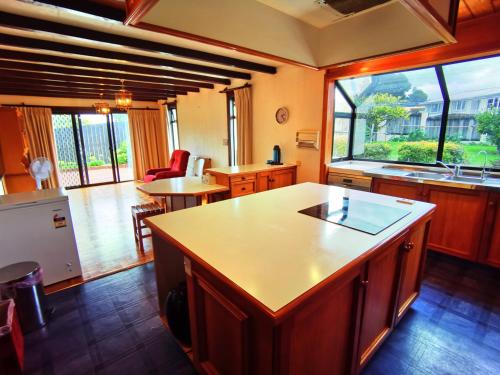 a kitchen with an island and a large window at Denby Golf House Tikipunga in Whangarei