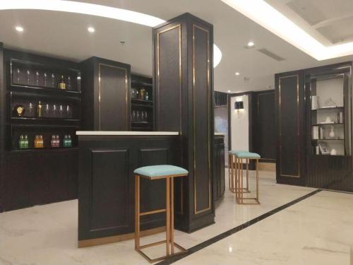 een bar met twee krukken in een kamer bij Xana Hotelle·Jinjiang Airport Yangguang Road Food court in Jinjiang