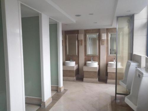 een badkamer met 2 wastafels en 2 spiegels bij Xana Hotelle·Jinjiang Airport Yangguang Road Food court in Jinjiang