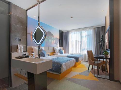 a bedroom with a bed with a sink and a mirror at Chonpines Hotel·s Liaocheng City Centre Wuxing Department Store in Liaocheng