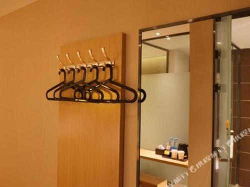 a bathroom with a rack of utensils on the wall at IU Hotel·Jiayuguan People's Shopping Mall in Jiayuguan