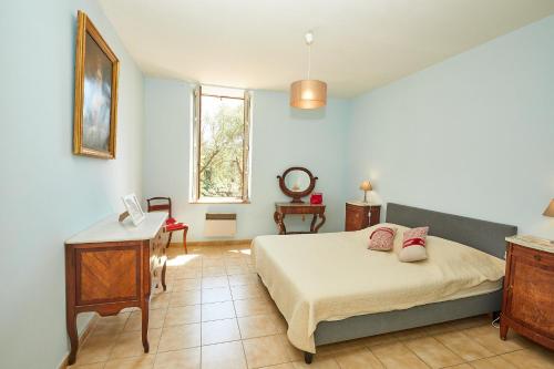 um quarto com uma cama, uma mesa e um espelho em Château de Sauvian em Sauvian