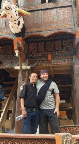 two men are standing in front of a building at Paul’s Homestay in Rantepao