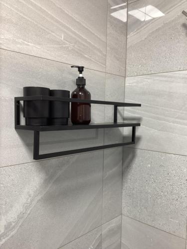 a bathroom with a shelf with a soap dispenser on it at Aachen Hotel in Liverpool