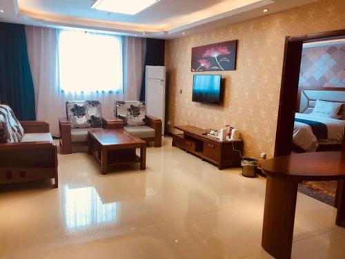 a hotel room with a bed and a living room at PAI Hotel·Luoyang Dingding Bei Road Hongjin Logistics International Peony Garden in Luoyang