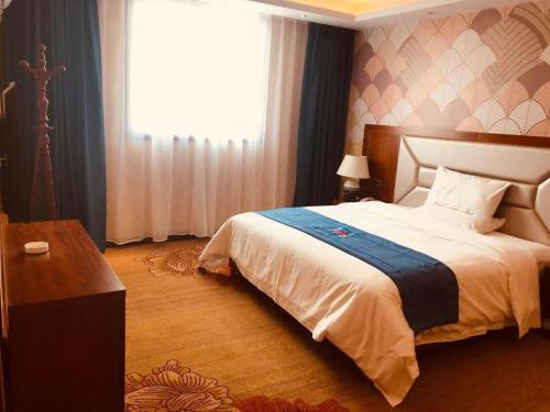 a bedroom with a large bed and a window at PAI Hotel·Luoyang Dingding Bei Road Hongjin Logistics International Peony Garden in Luoyang