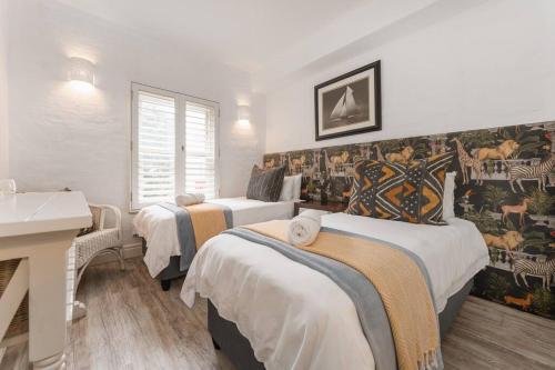 1 dormitorio con 2 camas y lavamanos en 4 Perissa- Luxury beach break, en Ballito