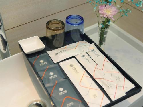 a tray with two packages on a table with flowers at Chonpines Hotel·Rizhao Yingbing Road RT-Mart in Rizhao