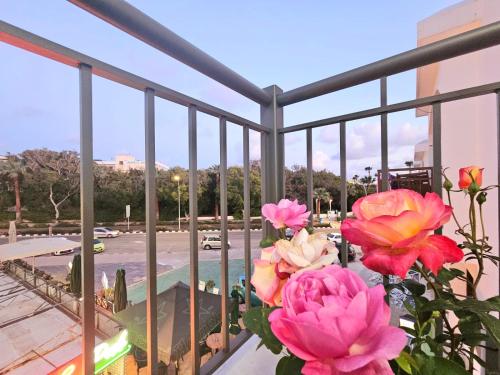 un ramo de flores rosas en un balcón en 1BD Beach Apartment, en Pafos