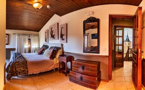 a bedroom with a bed and a mirror at Posada el Campanario in Rascafría