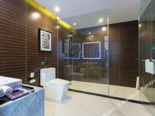 a bathroom with a toilet and a glass shower at Xana Hotelle·Liaocheng City Centre in Liaocheng