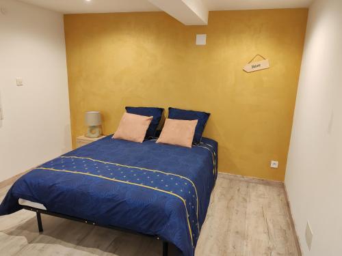 a bedroom with a blue bed with two pillows at Appartement T3 NEUF proche centre ville, Clim et Parking et Centrale EDF in Valence-dʼAgen
