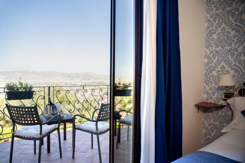 a bedroom with a balcony with a table and chairs at Relais Villa Giuliana in Licata