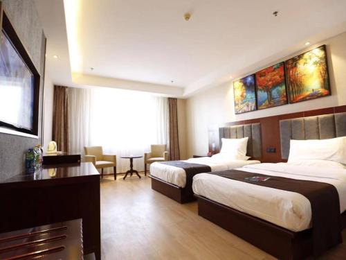 Habitación de hotel con 2 camas y escritorio en PAI Hotel·Changchun Jilin DaLu, en Changchún