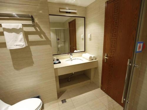 y baño con lavabo, aseo y espejo. en PAI Hotel·Changchun Jilin DaLu, en Changchún