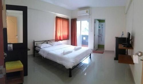 um quarto com uma cama grande e uma janela em New Home Nakhon Chai Si em Talat Amphoe Nakhon Chai Si